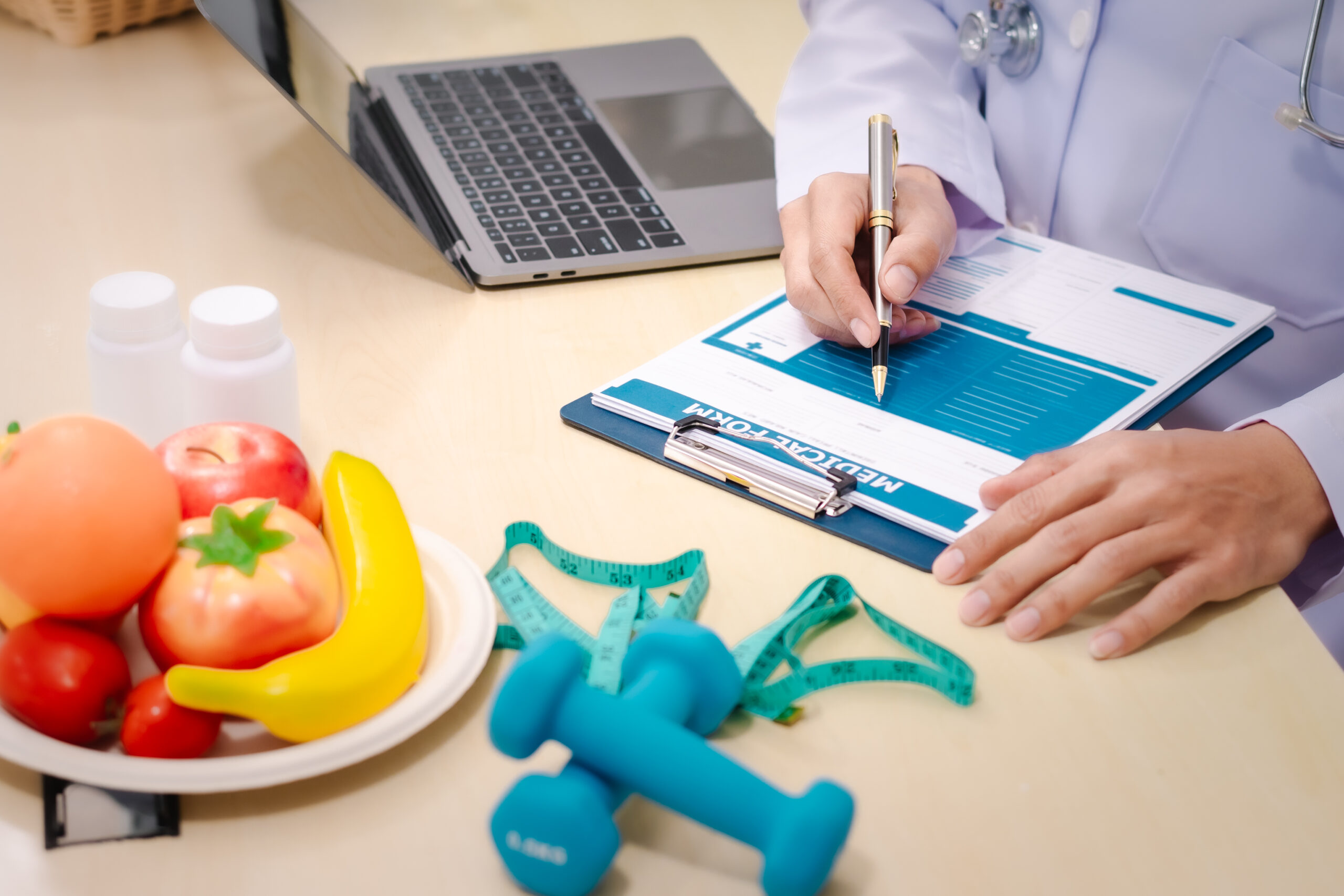 A male nutritionist sitting at a table, advising on healthy diets, promoting vegetable-based meals